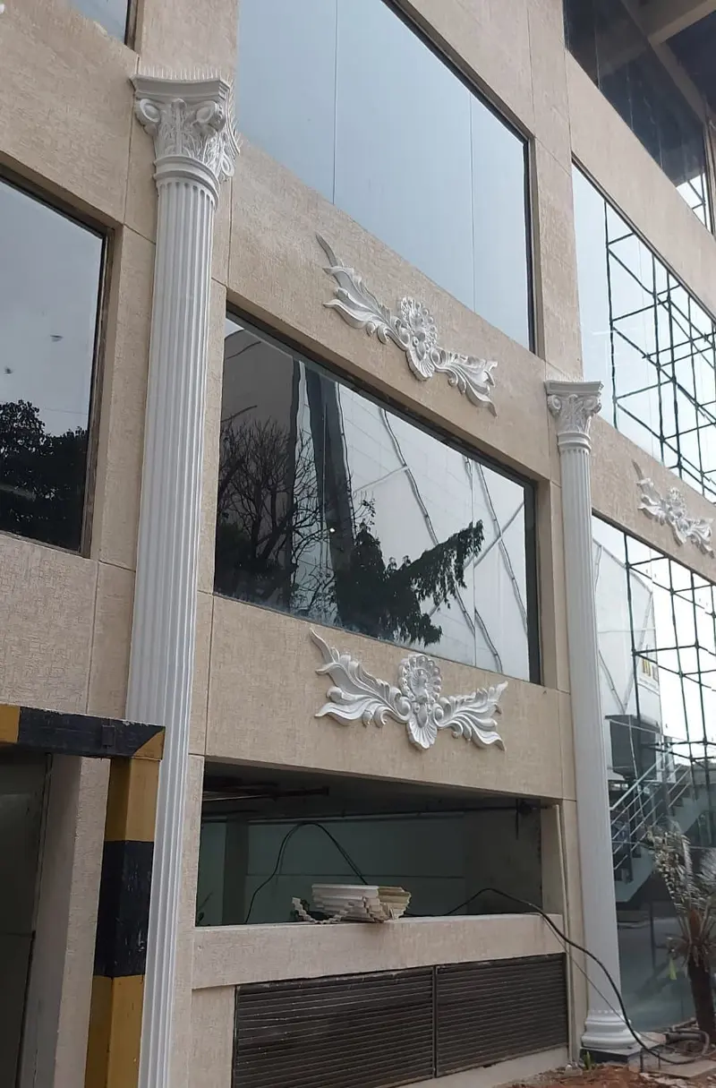 A fluted column rising past two floors of glazing beside carved panels