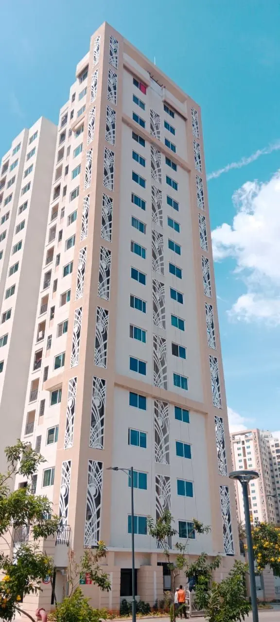Leaf-pattern panels on a Shriram Greenfield tower against a blue sky